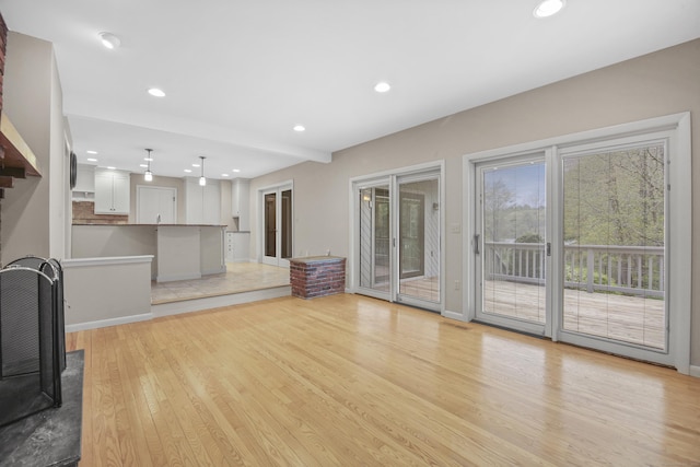 unfurnished living room featuring light wood-style floors, recessed lighting, and baseboards