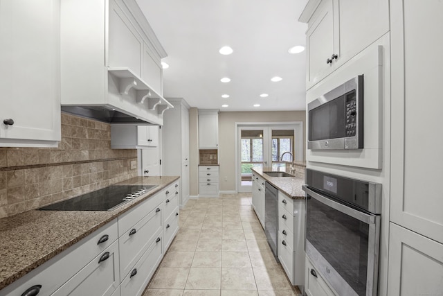 kitchen featuring stainless steel appliances, decorative backsplash, recessed lighting, white cabinetry, and light stone countertops