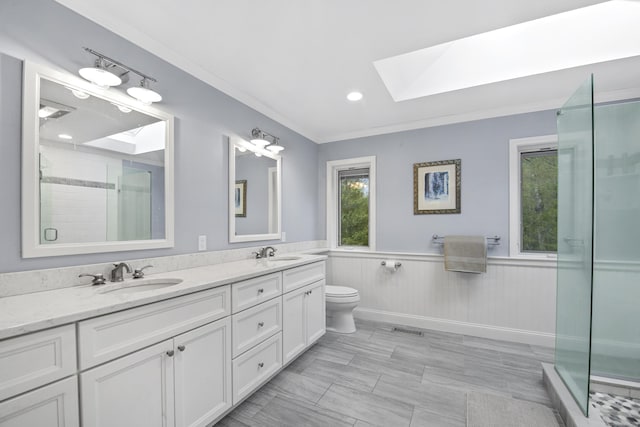 full bathroom featuring a skylight, a stall shower, double vanity, a wainscoted wall, and toilet