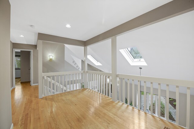 bonus room with a skylight, recessed lighting, and wood finished floors