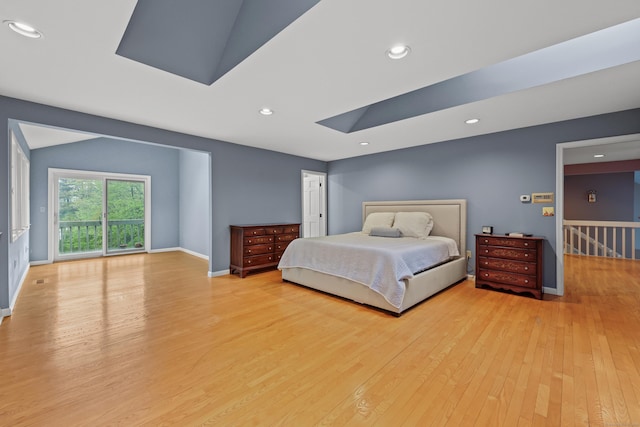 bedroom with a skylight, wood finished floors, recessed lighting, baseboards, and access to outside