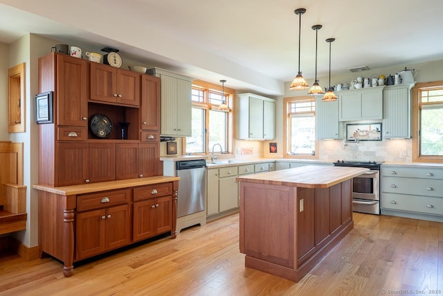 49 Bayberry Ln, Groton, CT 06340 - kitchen with stainless steel appliances, light wood-style floors, hanging light fixtures, a center island, and wood counters