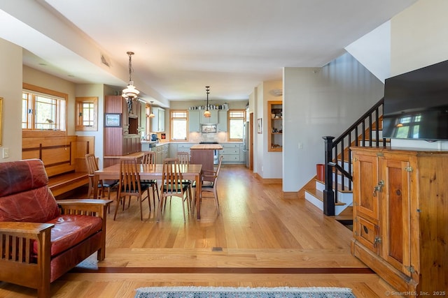 49 Bayberry Ln, Groton, CT 06340 - dining space featuring light wood-style floors, stairs, and healthy amount of natural light