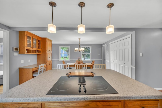 7 Beechwood Cir, Cromwell, CT 06416 - kitchen with black electric stovetop, brown cabinets, an island with sink, and a chandelier