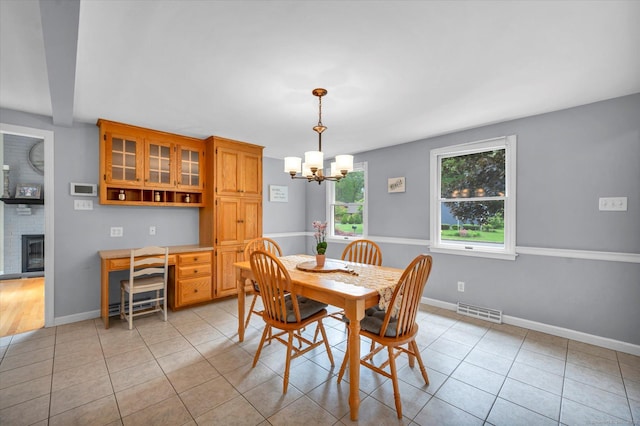 7 Beechwood Cir, Cromwell, CT 06416 - dining room with a chandelier, light tile patterned flooring, a fireplace, and baseboards