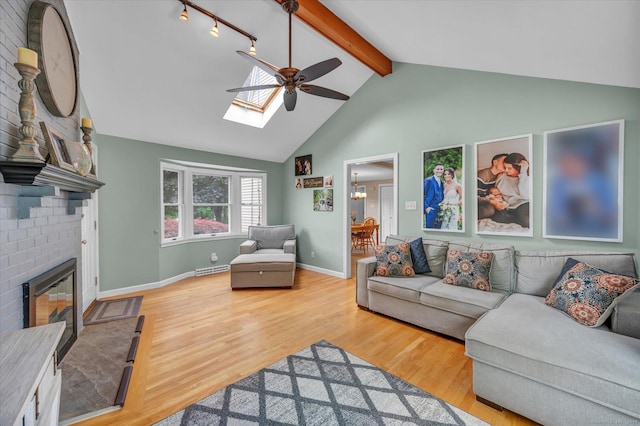 7 Beechwood Cir, Cromwell, CT 06416 - living room featuring a ceiling fan, beamed ceiling, wood finished floors, a skylight, and a fireplace