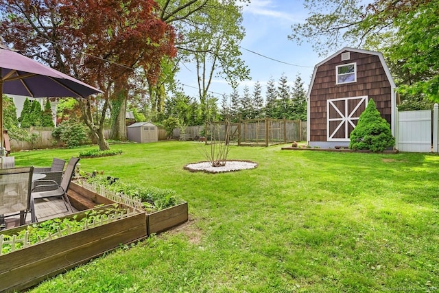 view of yard featuring a shed, an outbuilding, and a vegetable garden