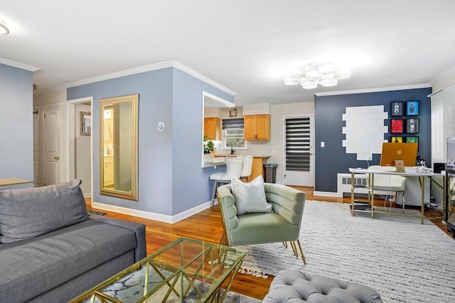 living room featuring an office area, a chandelier, light wood-type flooring, ornamental molding, and baseboards
