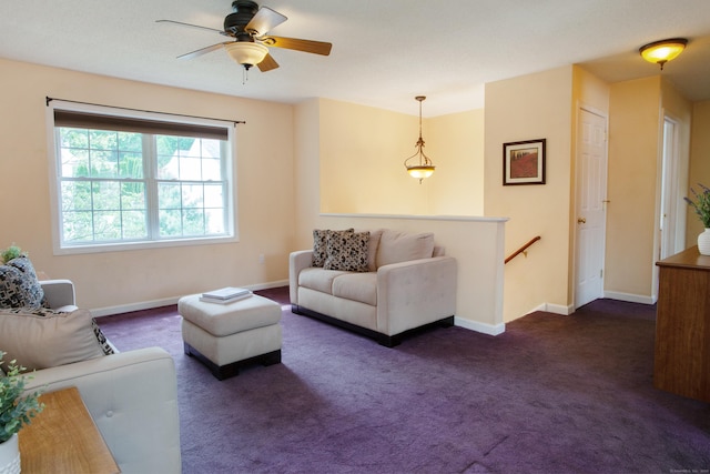 living area featuring dark carpet, baseboards, and a ceiling fan