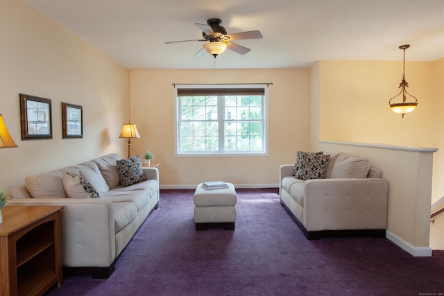 carpeted living room featuring ceiling fan and baseboards