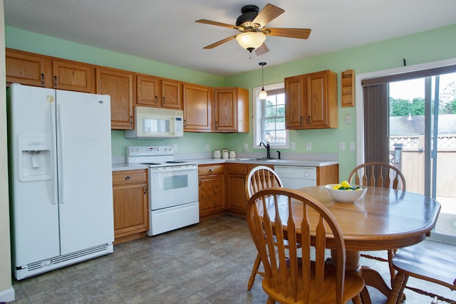 kitchen with white appliances, a sink, light countertops, a ceiling fan, and brown cabinets