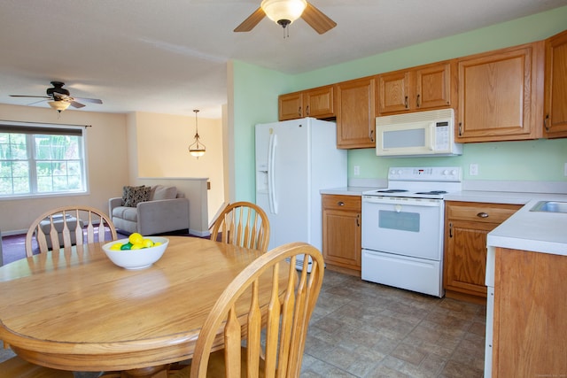 kitchen featuring white appliances, a ceiling fan, light countertops, stone finish flooring, and a sink