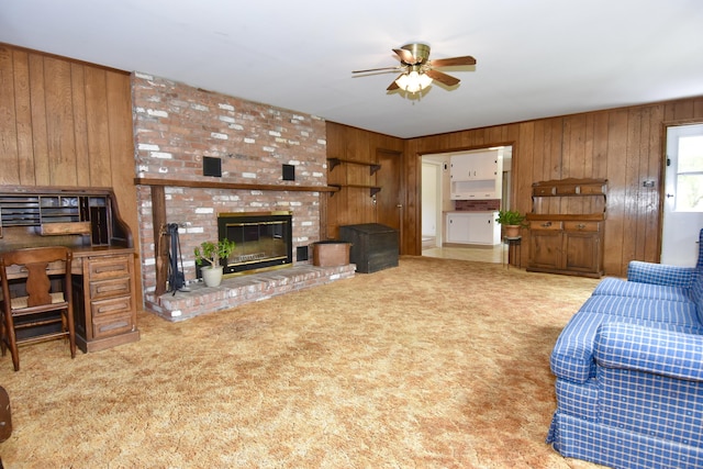 12 Cedar Ln, Oxford, CT 06478 - carpeted living room with wood walls, a ceiling fan, and a fireplace