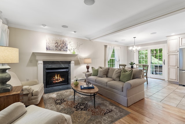 79 Erdoni Rd, Columbia, CT 06237 - living area featuring a chandelier, a premium fireplace, a baseboard radiator, ornamental molding, and light wood-type flooring