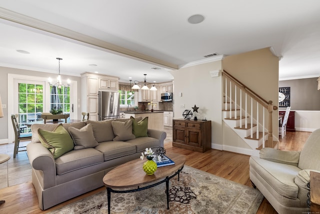 79 Erdoni Rd, Columbia, CT 06237 - living room featuring a chandelier, stairs, baseboards, light wood-style floors, and crown molding