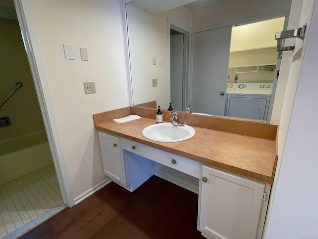 bathroom with vanity, wood finished floors, and washer / clothes dryer