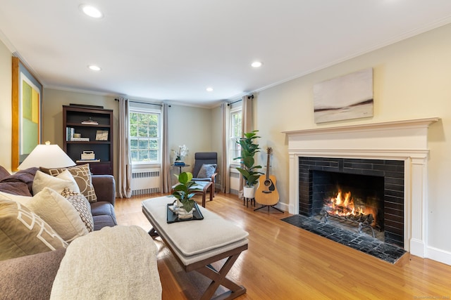 46 Glenbrook Rd, West Hartford, CT 06107 - living room with radiator, a fireplace with flush hearth, ornamental molding, light wood-style flooring, and recessed lighting