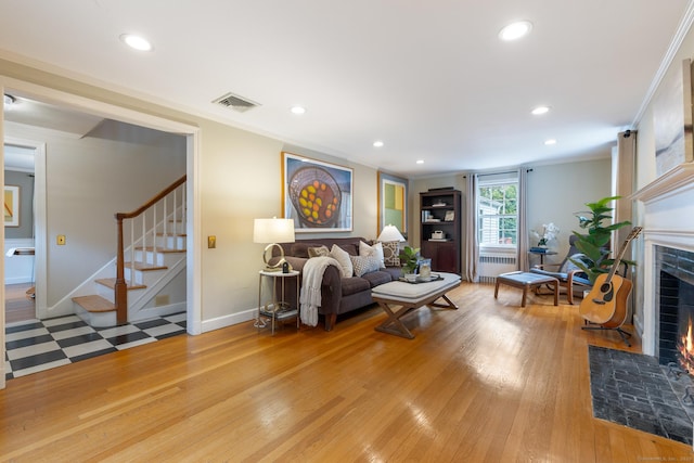 46 Glenbrook Rd, West Hartford, CT 06107 - living room featuring ornamental molding, radiator heating unit, a fireplace with flush hearth, light wood-style floors, and stairway