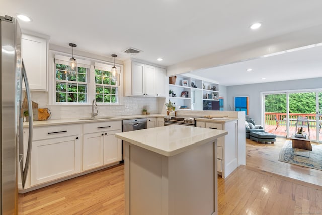 46 Glenbrook Rd, West Hartford, CT 06107 - kitchen featuring a sink, a peninsula, light wood finished floors, open floor plan, and white cabinetry