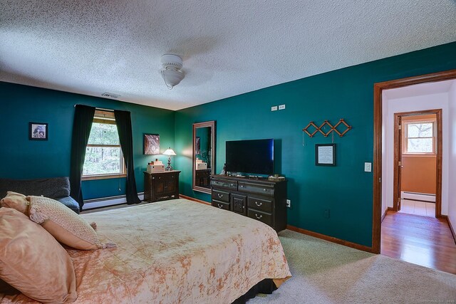 7 Stonegate Rd, East Hampton, CT 06424 - bedroom featuring a baseboard heating unit, multiple windows, a textured ceiling, baseboards, and baseboard heating