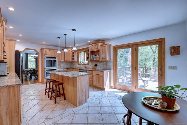 7 Stonegate Rd, East Hampton, CT 06424 - kitchen featuring stainless steel double oven, arched walkways, a center island with sink, light stone countertops, and recessed lighting