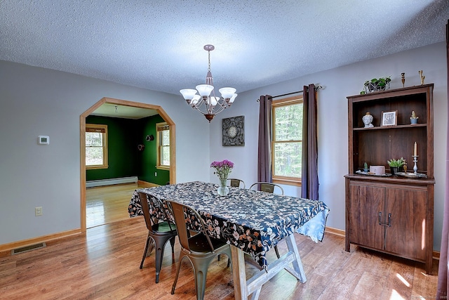 7 Stonegate Rd, East Hampton, CT 06424 - dining space featuring arched walkways, light wood-type flooring, a chandelier, baseboard heating, and a textured ceiling