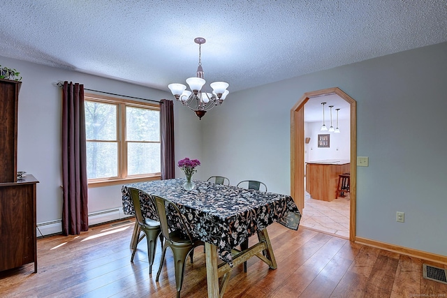 7 Stonegate Rd, East Hampton, CT 06424 - dining space featuring a chandelier, wood-type flooring, a textured ceiling, and arched walkways