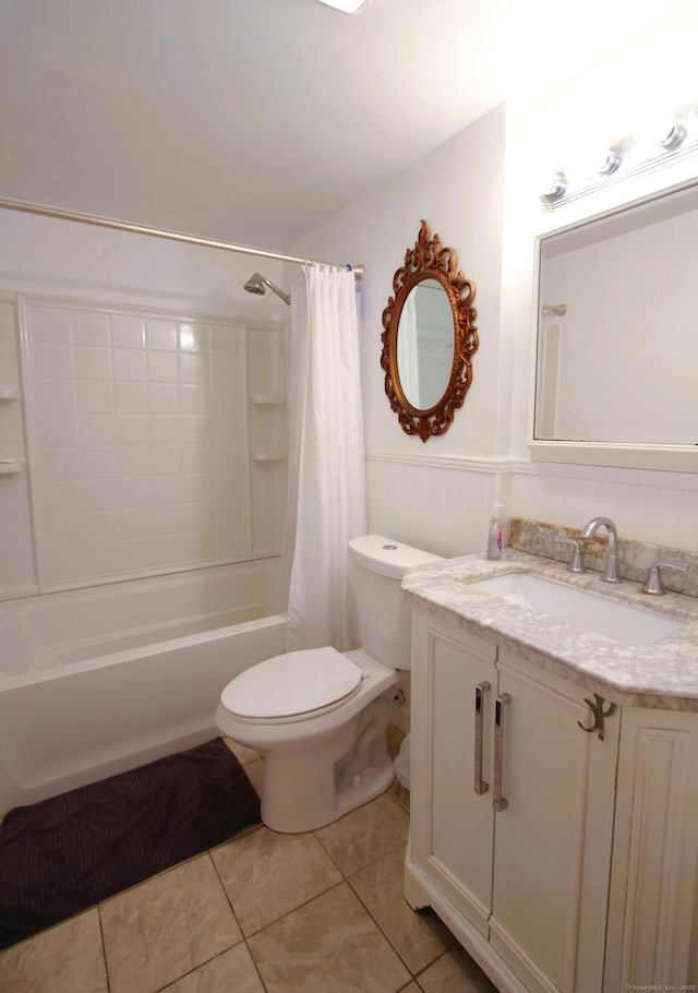bathroom with tile patterned floors, toilet, vanity, shower / tub combo with curtain, and wainscoting