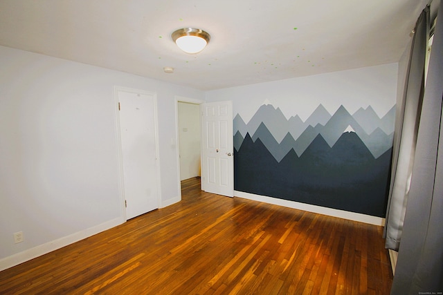 spare room featuring hardwood / wood-style floors and baseboards