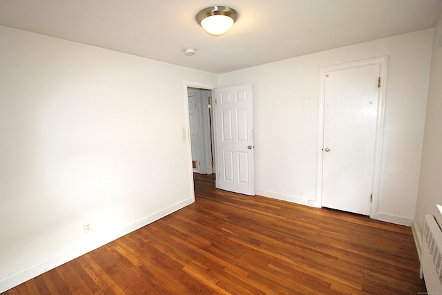 unfurnished bedroom featuring wood finished floors and baseboards