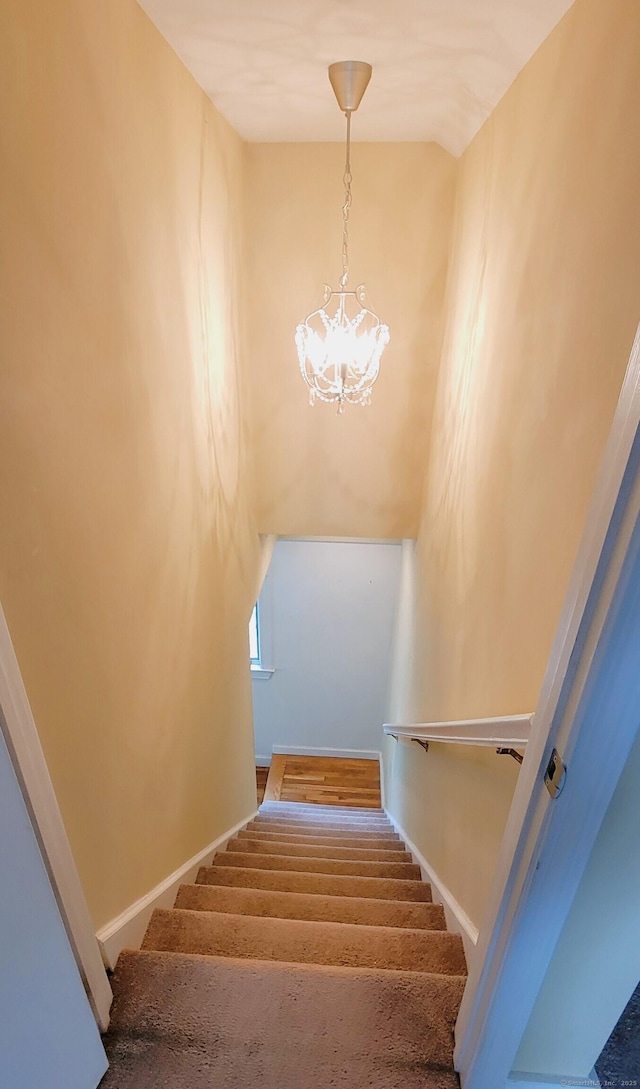 stairway with a chandelier and baseboards