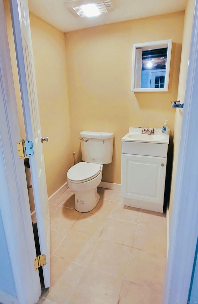 bathroom featuring toilet, tile patterned flooring, vanity, and baseboards