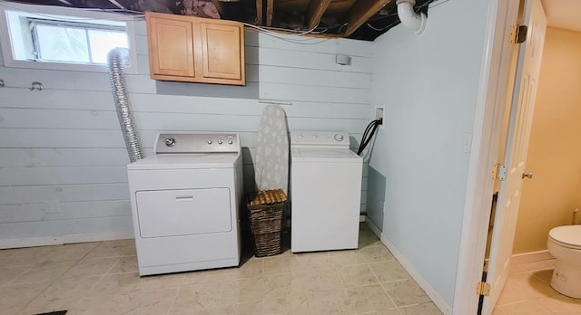 washroom with washer and dryer, cabinet space, and light tile patterned floors