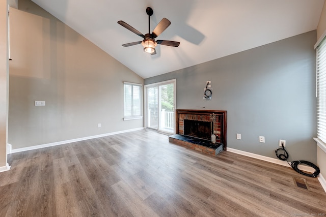 unfurnished living room featuring a ceiling fan, a fireplace, wood finished floors, baseboards, and high vaulted ceiling