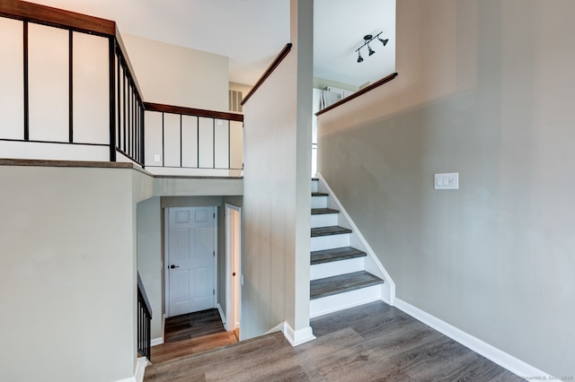 stairs with wood finished floors and baseboards