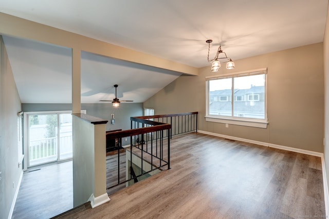 additional living space featuring wood finished floors, plenty of natural light, baseboards, vaulted ceiling, and ceiling fan