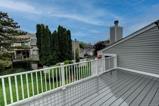 wooden deck featuring a lawn
