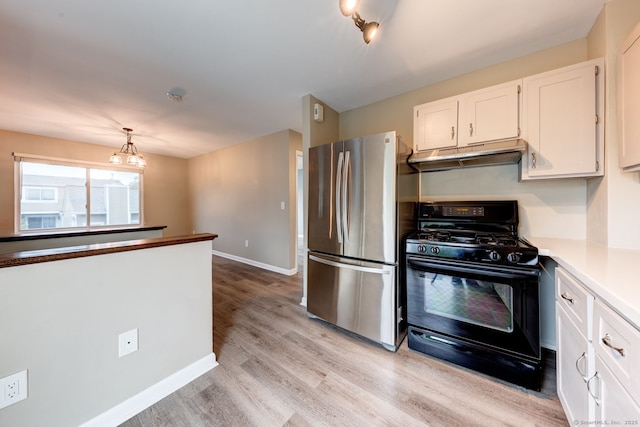 kitchen with freestanding refrigerator, gas stove, light wood-type flooring, white cabinetry, and under cabinet range hood