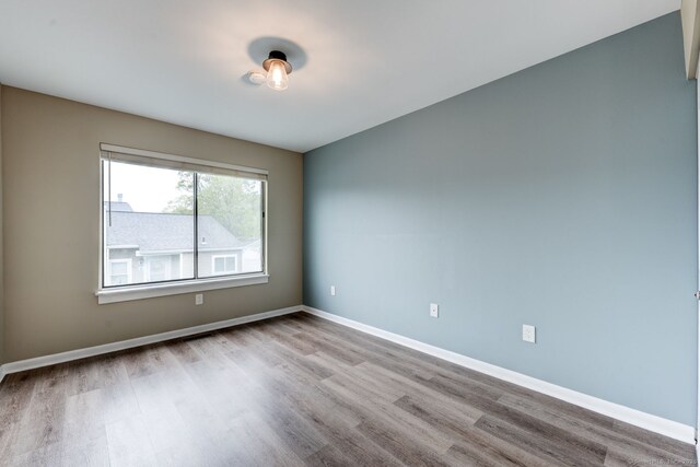 unfurnished room featuring wood finished floors and baseboards