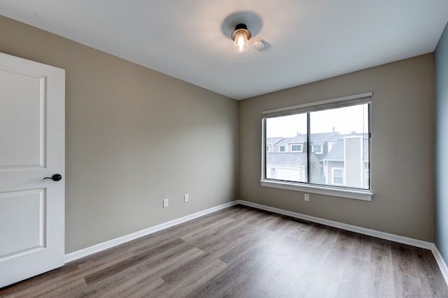 empty room with wood finished floors and baseboards