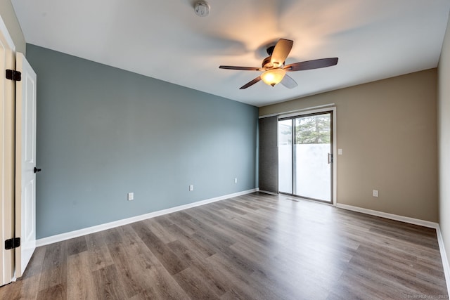 unfurnished room with a ceiling fan, wood finished floors, baseboards, and a smoke detector