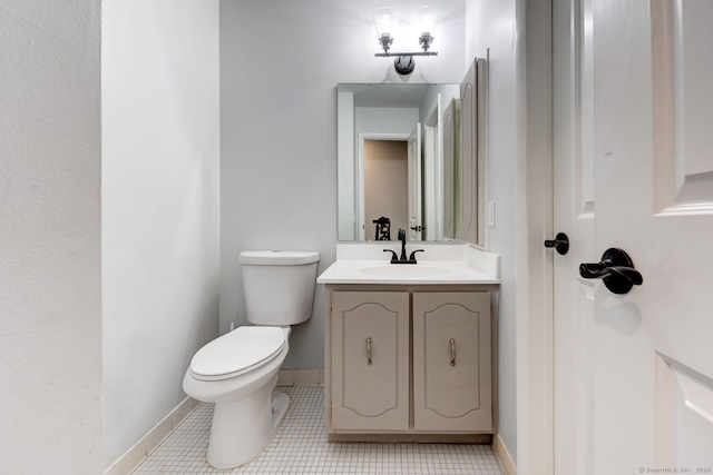 half bathroom with toilet, vanity, and baseboards