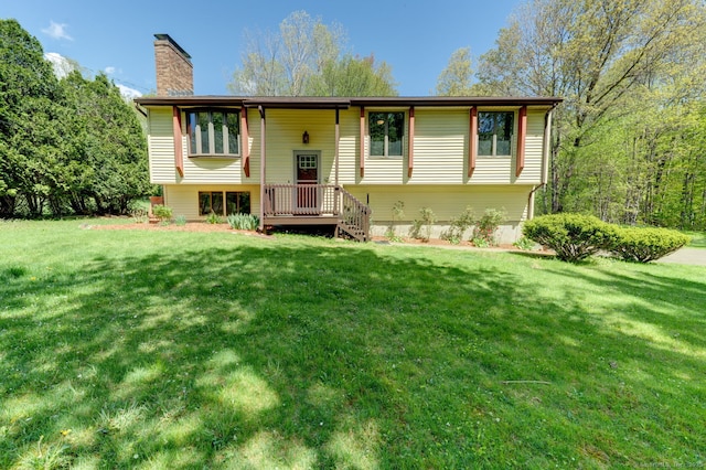 back of property with a chimney and a yard
