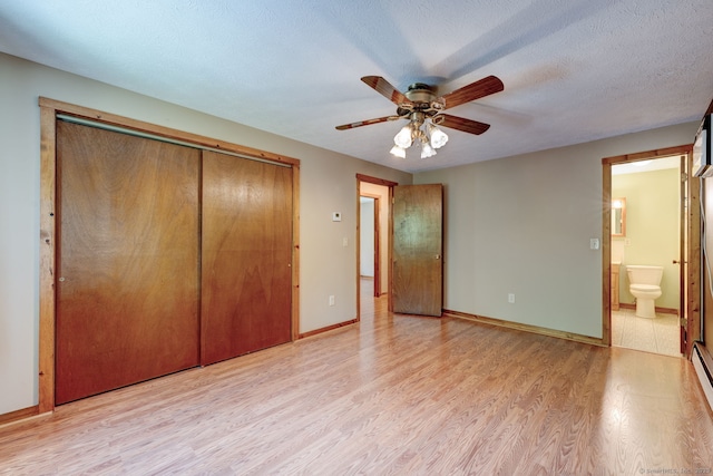 unfurnished bedroom featuring light wood-type flooring, a closet, baseboards, connected bathroom, and a ceiling fan