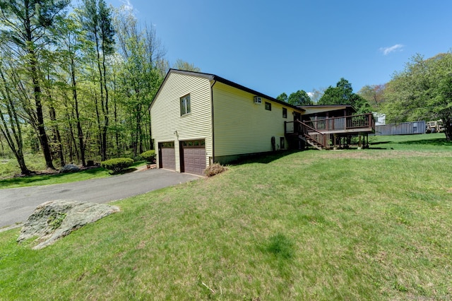 view of home's exterior featuring stairway, a garage, a wooden deck, asphalt driveway, and a yard