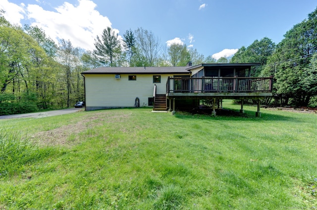 back of property featuring a wooden deck, stairs, and a lawn