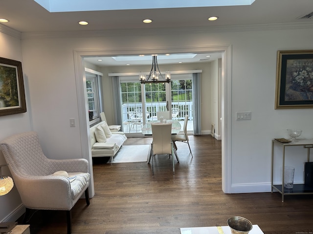 dining room featuring a chandelier, dark wood-style floors, baseboards, a skylight, and crown molding