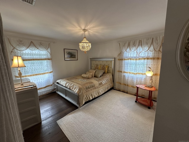 bedroom featuring multiple windows, a chandelier, ornamental molding, and wood finished floors