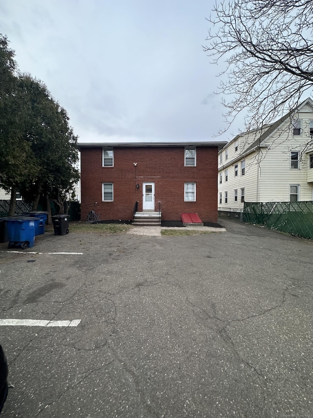 74 Saltonstall Ave, New Haven, CT 06513 - rear view of house featuring fence, uncovered parking, and brick siding