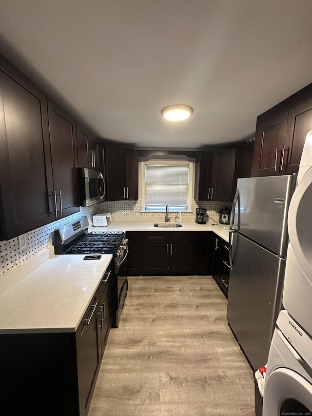 74 Saltonstall Ave, New Haven, CT 06513 - kitchen with stainless steel appliances, a sink, stacked washer / dryer, light countertops, and tasteful backsplash